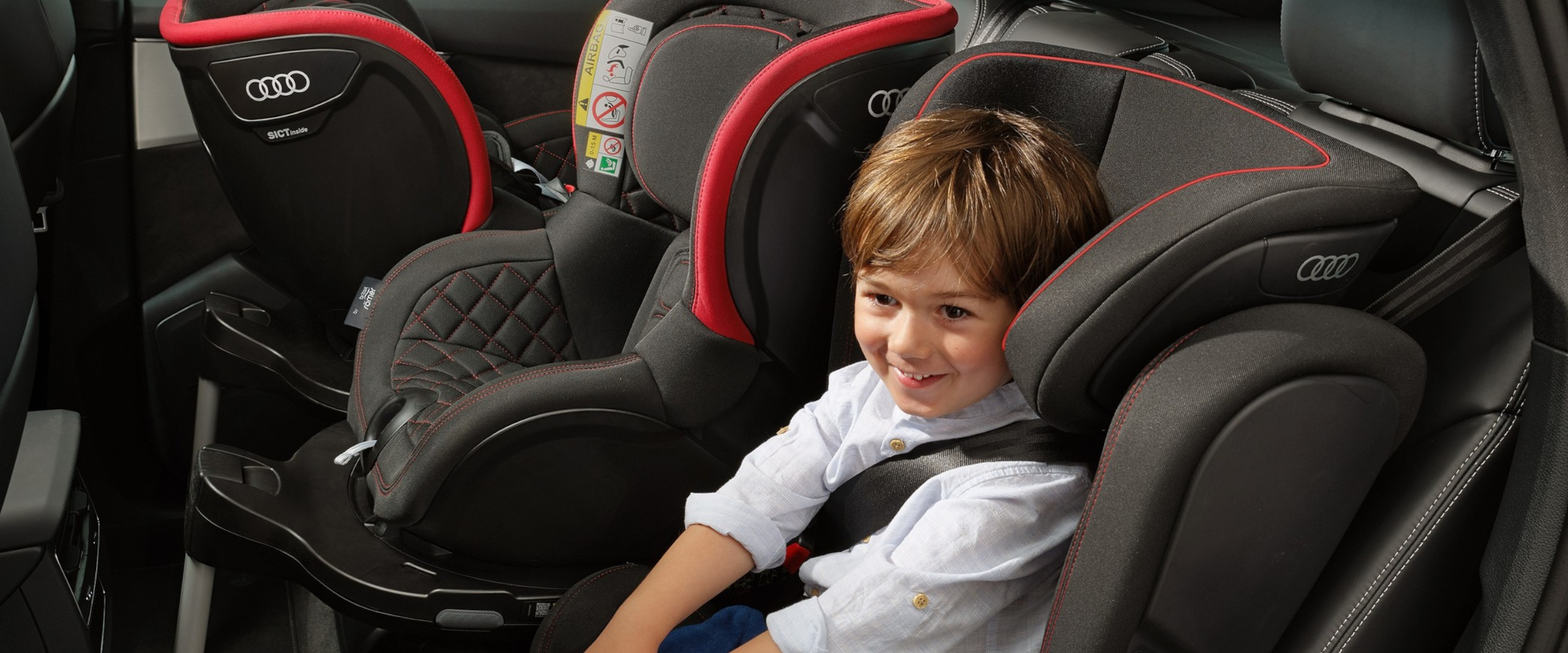 Kind sitzt in einem Kindersitz von Audi